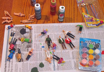 Inexpensive plastic figures ordered in bulk from China, being painted with acrylic craft paints. Click for bigger photo.