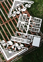 These parts from a Piko cabin kit came on separate sprues. In this case, it was easier to lay them out to paint. I primed them and the parts in the next two photos with white primer. Click for bigger photo.